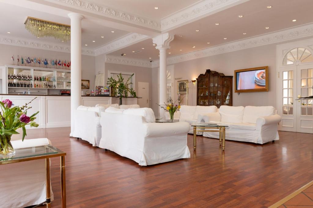 a living room with white chairs and a table at Hotel Commodore in Hamburg