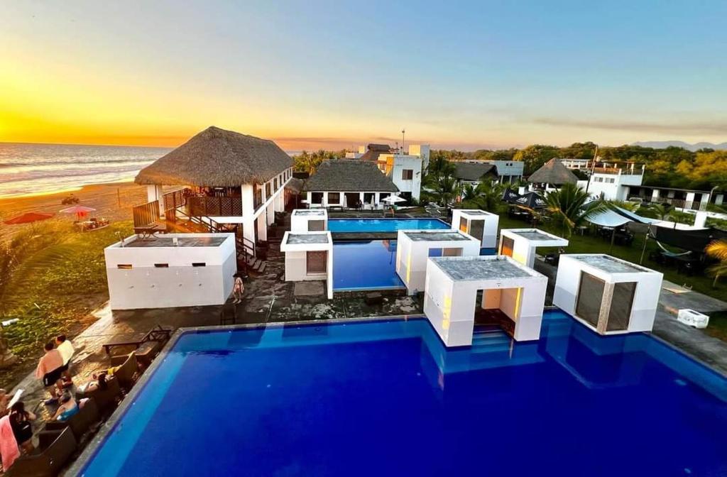 an aerial view of a resort with a pool and the beach at Hotel Maya Jade in Monterrico