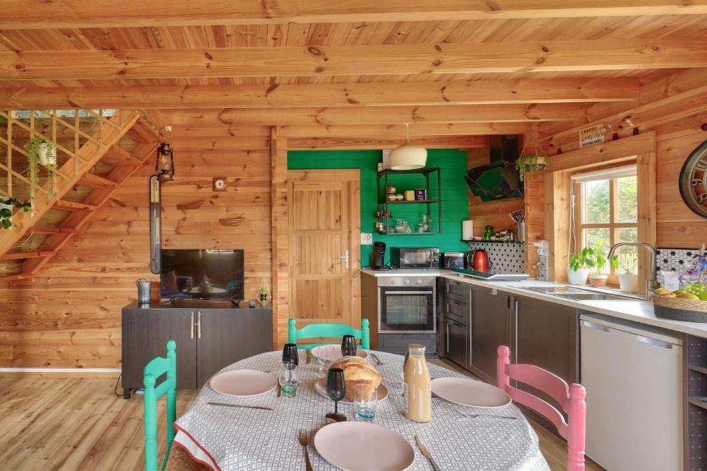 a kitchen with a table and chairs in a cabin at Paisible et insolite chalet pour 4 personnes a Penmarch in Penmarch