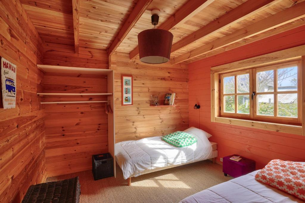 a bedroom in a log cabin with two beds at Paisible et insolite chalet pour 4 personnes a Penmarch in Penmarch