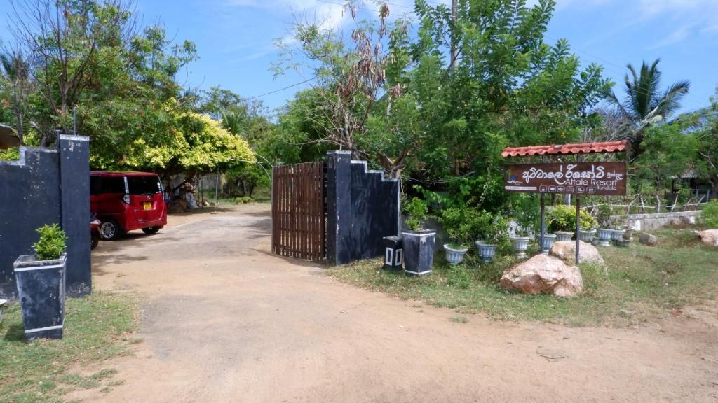 a gate with a sign next to a dirt road at Attale Resort in Hambantota