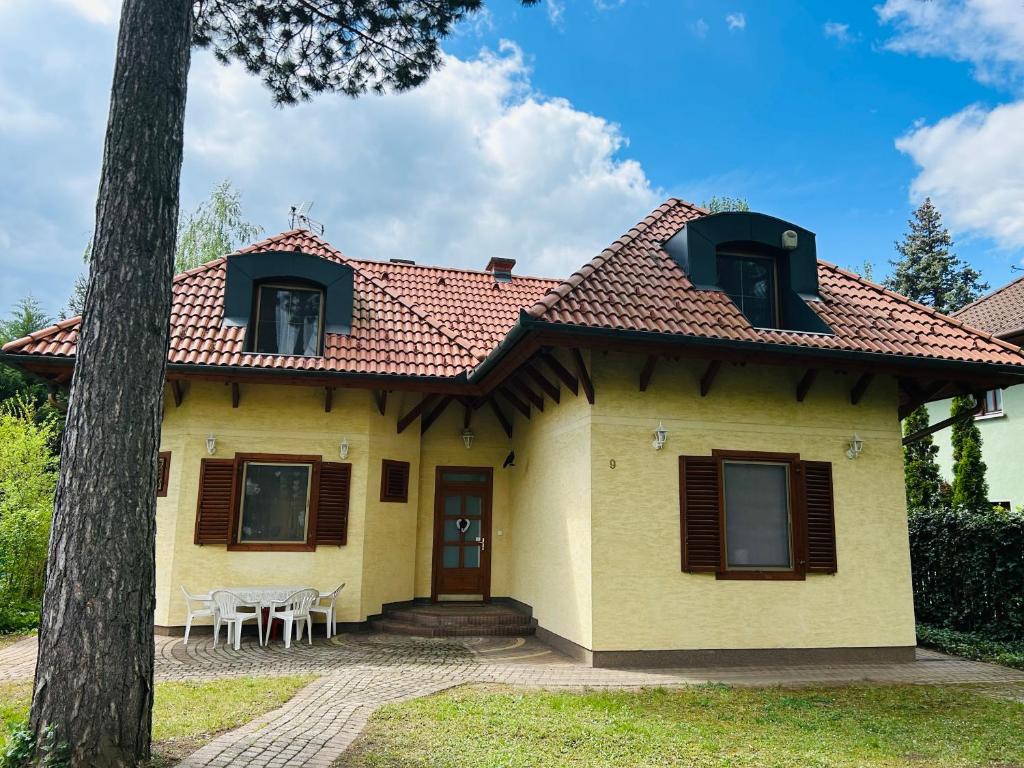 uma casa amarela com um telhado vermelho em Nefelejts Deluxe Home em Zamárdi