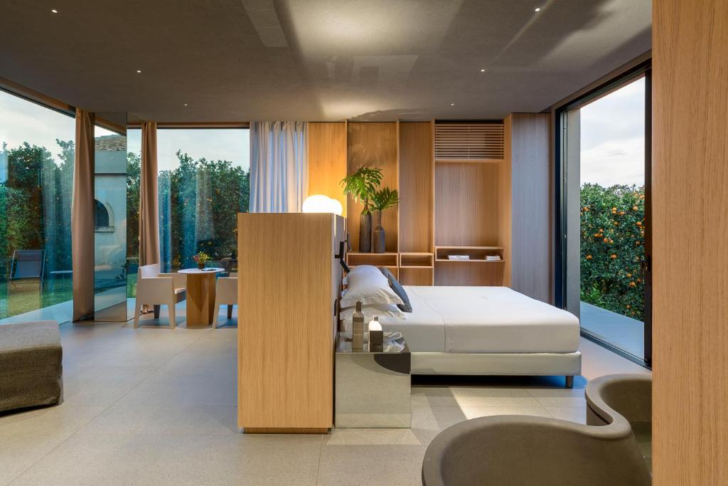 een slaapkamer met een wit bed en een tafel bij Zash Country Boutique hotel & SPA in Giarre