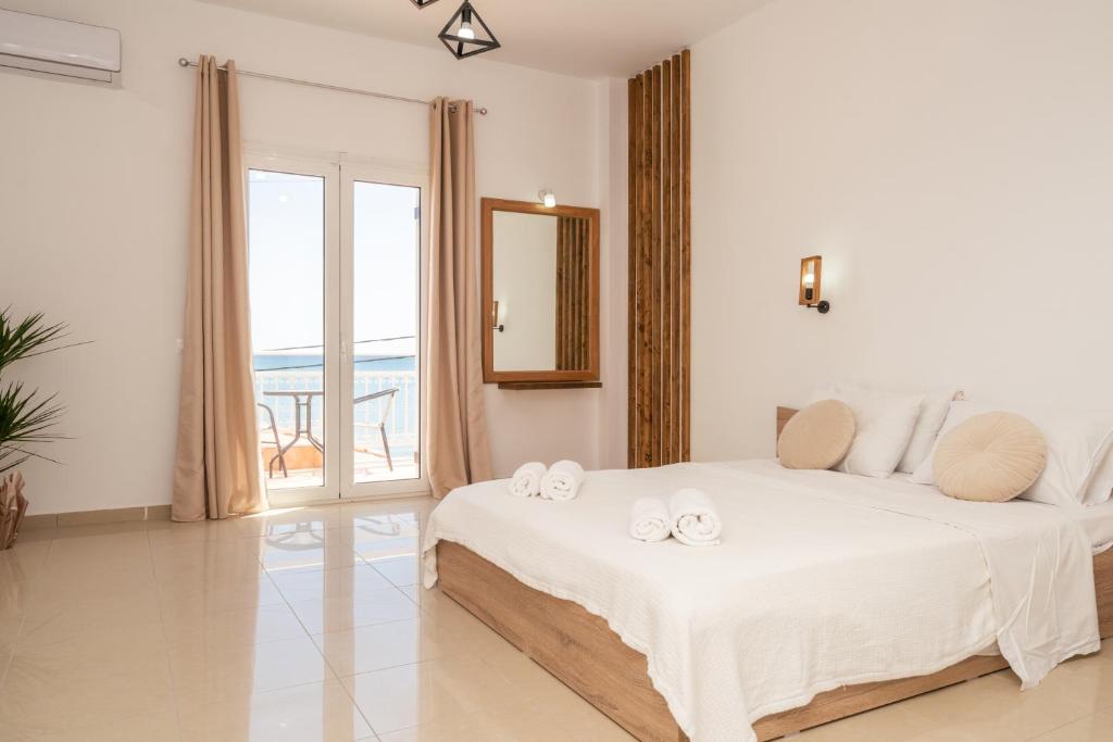 a bedroom with a large bed with towels on it at C'est La Vie Rooms and Suites in Laganas