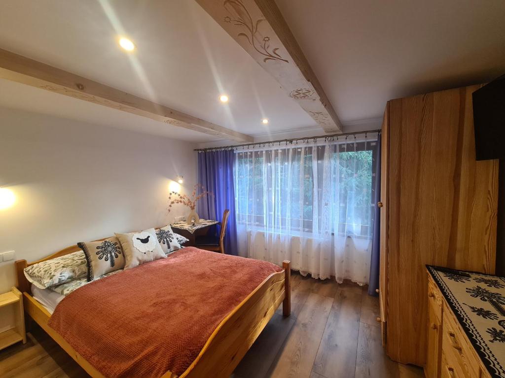 a bedroom with a large bed and a window at Apartamenty U Samków in Zakopane