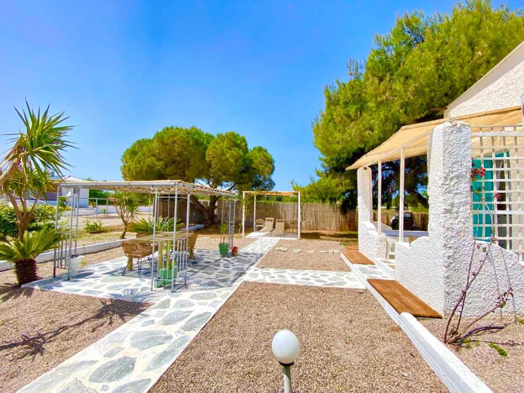 a patio with a table and chairs and trees at Unique Cycladic Detached House - Private Garden - Helena in Análipsis