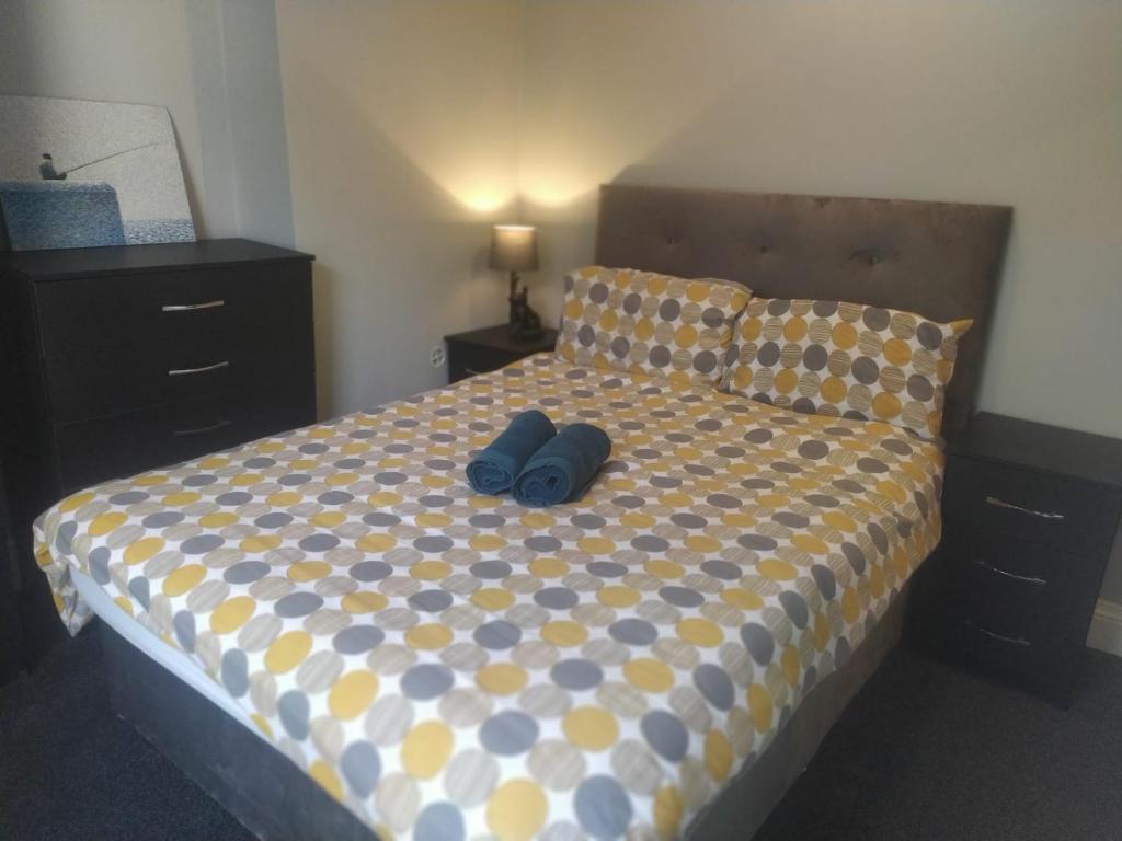 a bed with two pairs of shoes sitting on it at The Old White Hart Brewery Guesthouse in Bath