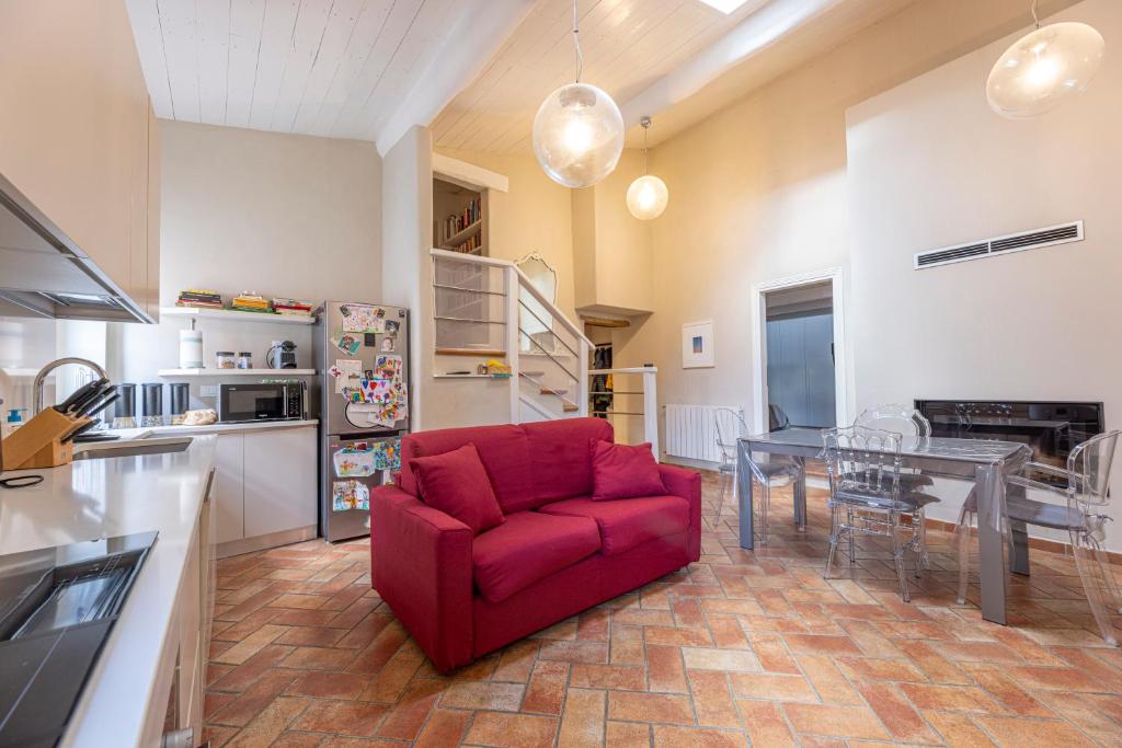 a living room with a red chair and a table at Il Nido di Bianca - Goelba in Portoferraio