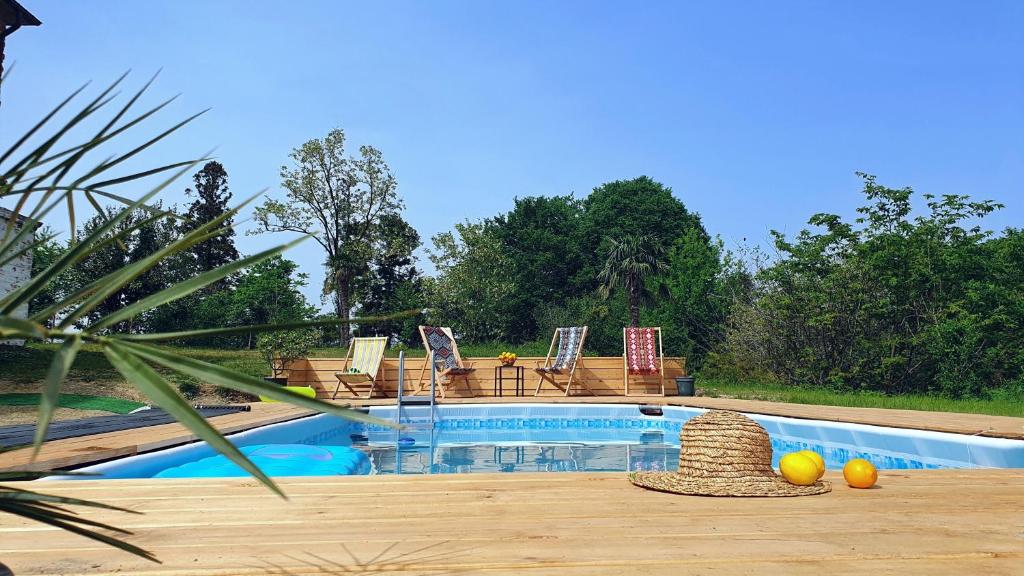 een zwembad met stoelen en een tafel met fruit op het terras bij Villa Natanebi 