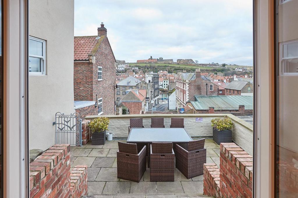 a balcony with a table and a view of a city at Pecks Cottage in Whitby