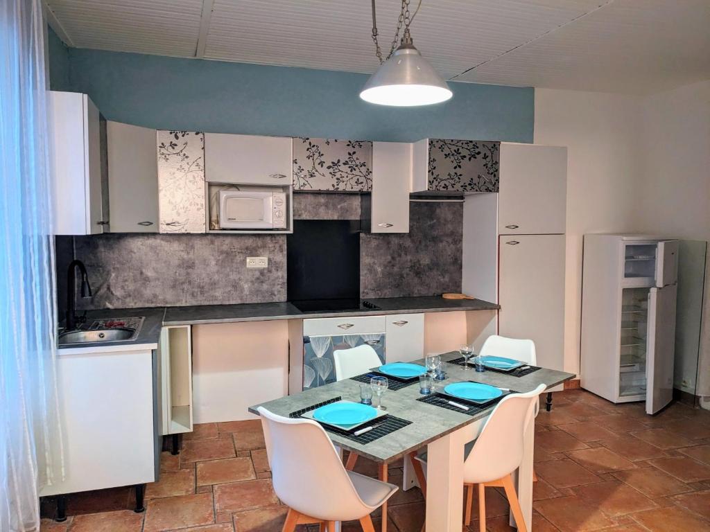 une cuisine avec une table et des chaises dans une pièce dans l'établissement Vacances à Sète, à Sète