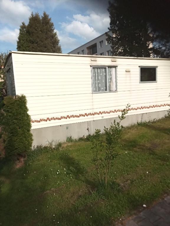 eine weiße Wand mit einem Fenster auf einem Haus in der Unterkunft Mobilní dům Venda in Hradišťko