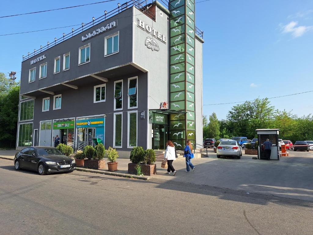 un edificio con gente caminando delante de él en Hotel Georgian Memory en Kutaisi