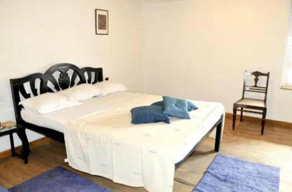 - un lit blanc avec des oreillers bleus dans l'établissement Hotel Niyati Guest House, à Vieux-Goa