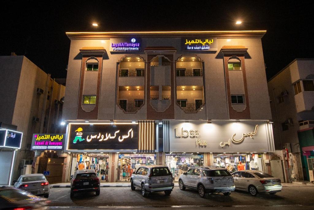 a building with cars parked in a parking lot at Layali Al Tamayoz 2 in Jeddah