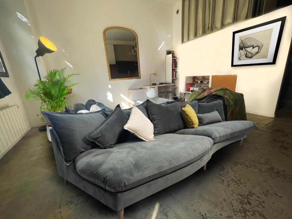 a living room with a gray couch with pillows at Design loft in Saint-Denis