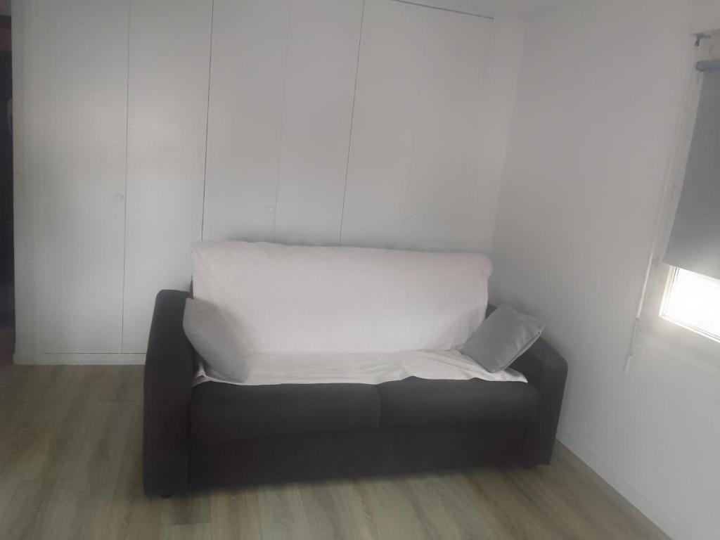 薩塞勒的住宿－Studio à 15 min du stade de France et de la gare du Nord，上面有一条白色毯子的沙发