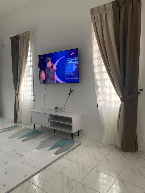 a living room with a flat screen tv on a wall at Homestay muslim adawiyah Nilai in Nilai