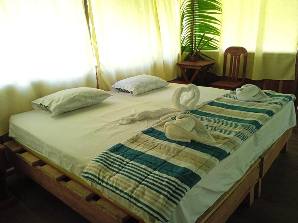 ein Bett mit Handtüchern und Kissen darüber in der Unterkunft Amazon Jungle Reps in Nauta