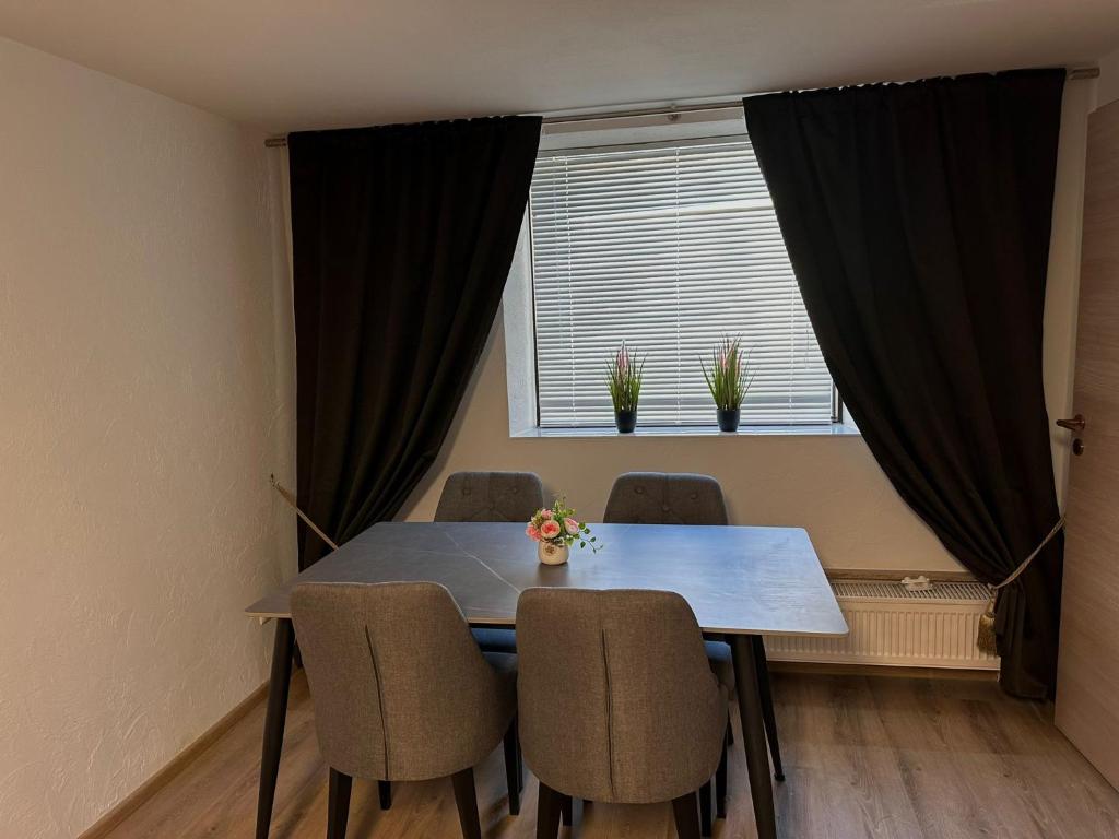 a dining room table with chairs and a window at Zwei Zimmer Wohnung mit Küche in Kuchen