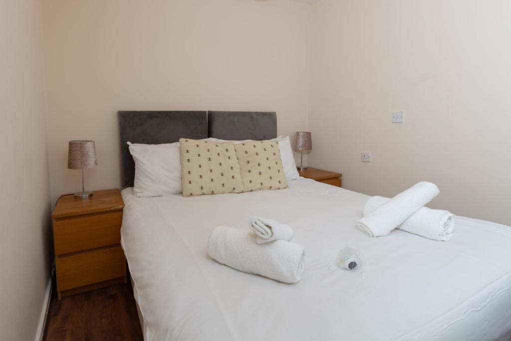 um quarto com uma cama branca e toalhas em Centrally Located 1Bed Apt in Stretford em Manchester