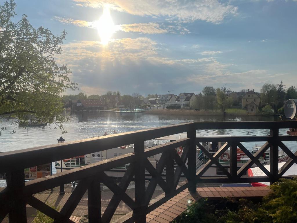 een brug over een rivier met mensen op het strand bij Apartament Mazurek przy Promenadzie in Mikołajki