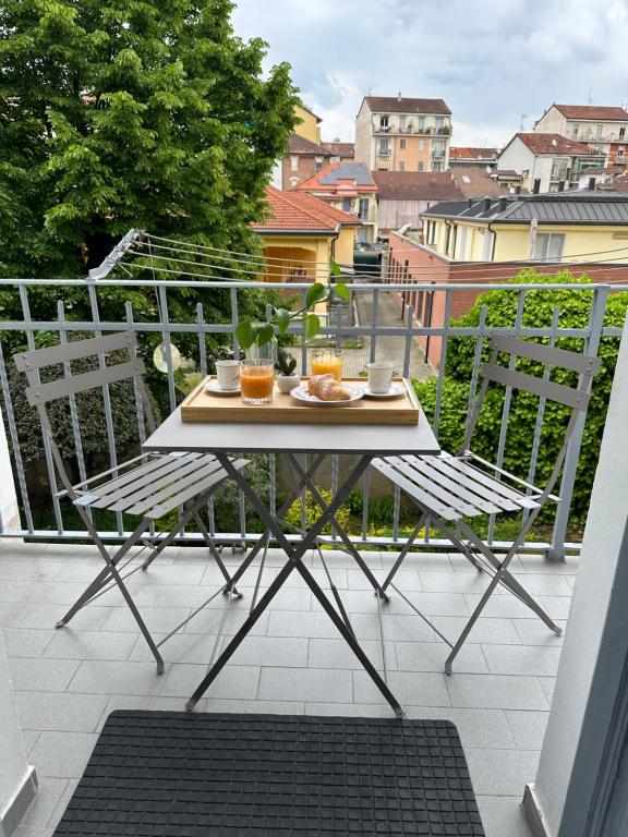 Una mesa y dos sillas en un balcón. en Dora’s Stay, en Turín