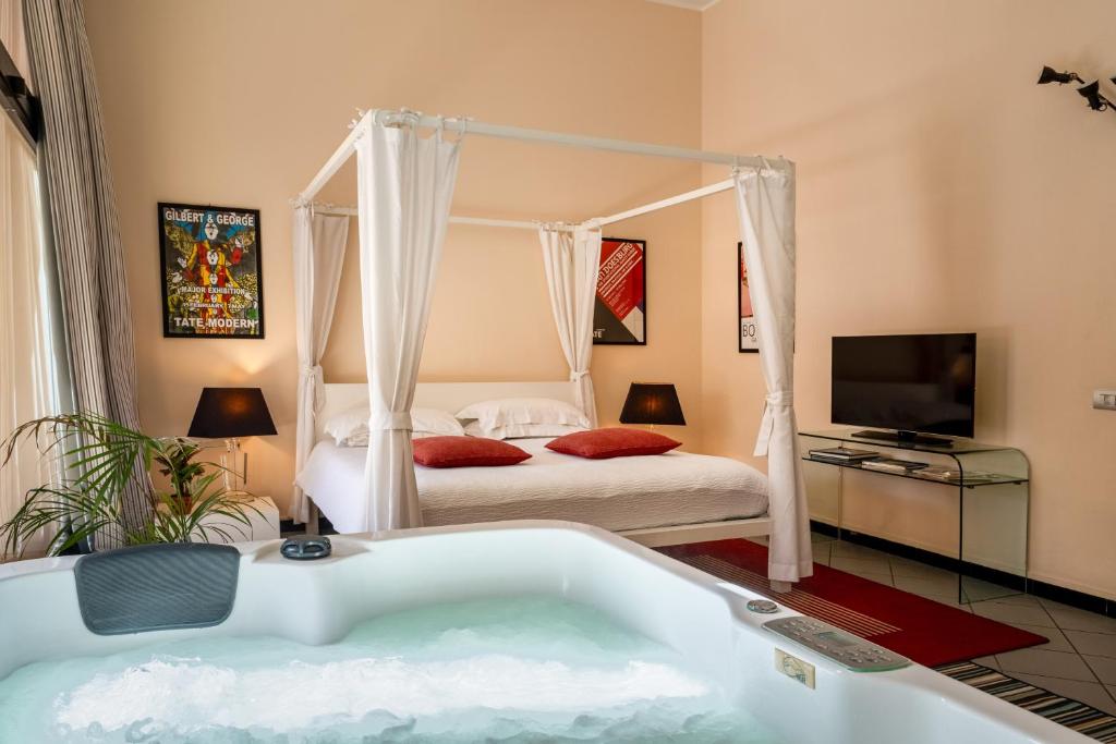 カリアリにあるSnob Luxury Suiteのバスルーム(バスタブ付)、ベッド1台、テレビが備わります。