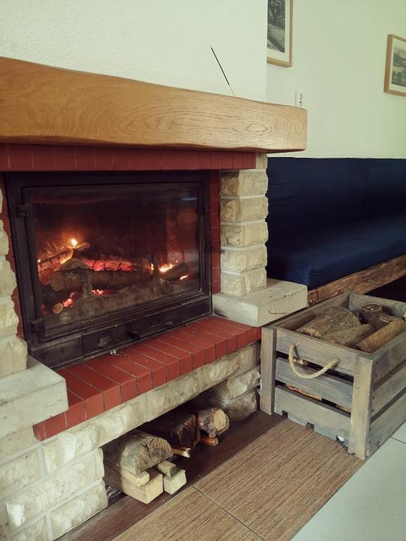 Cozy fireplace with burning logs, surrounded by brick and wood.