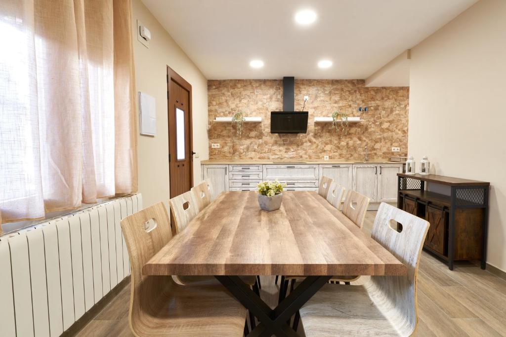 comedor con mesa de madera y sillas en Casa Rural El Paloteo en Segovia