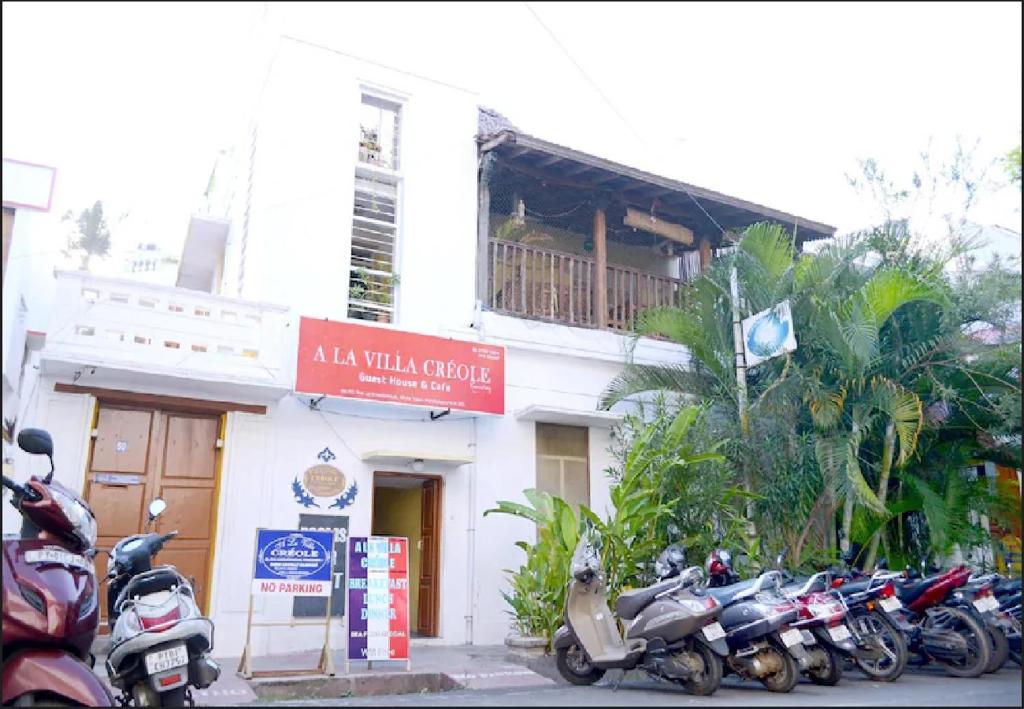 un grupo de motocicletas estacionadas frente a un edificio en LA VILLA CREOLE en Pondicherry