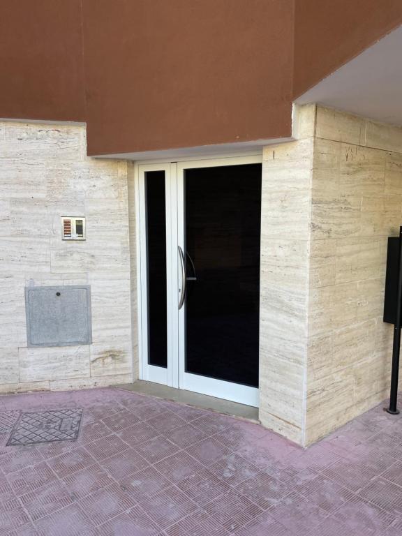 eine große Glastür in einem Gebäude mit Ziegelwand in der Unterkunft condominio stella in Margherita di Savoia