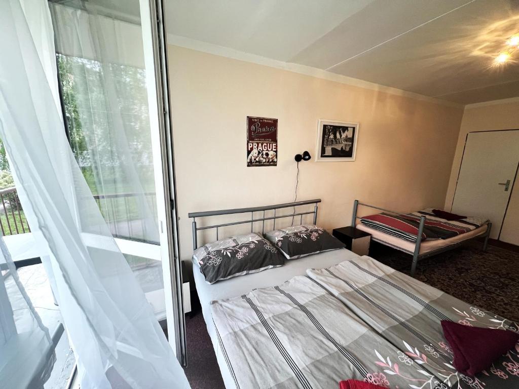 um quarto com uma cama e uma janela em Hotel Penzion Rohožník em Praga