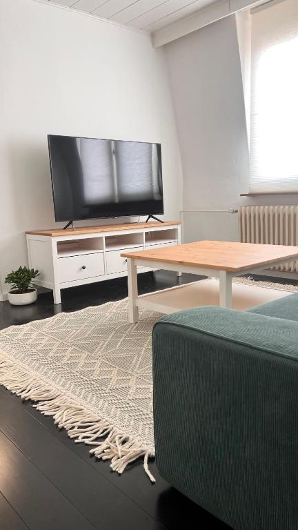 sala de estar con TV de pantalla plana y mesa en Wohnung in Kirchditmold en Kassel