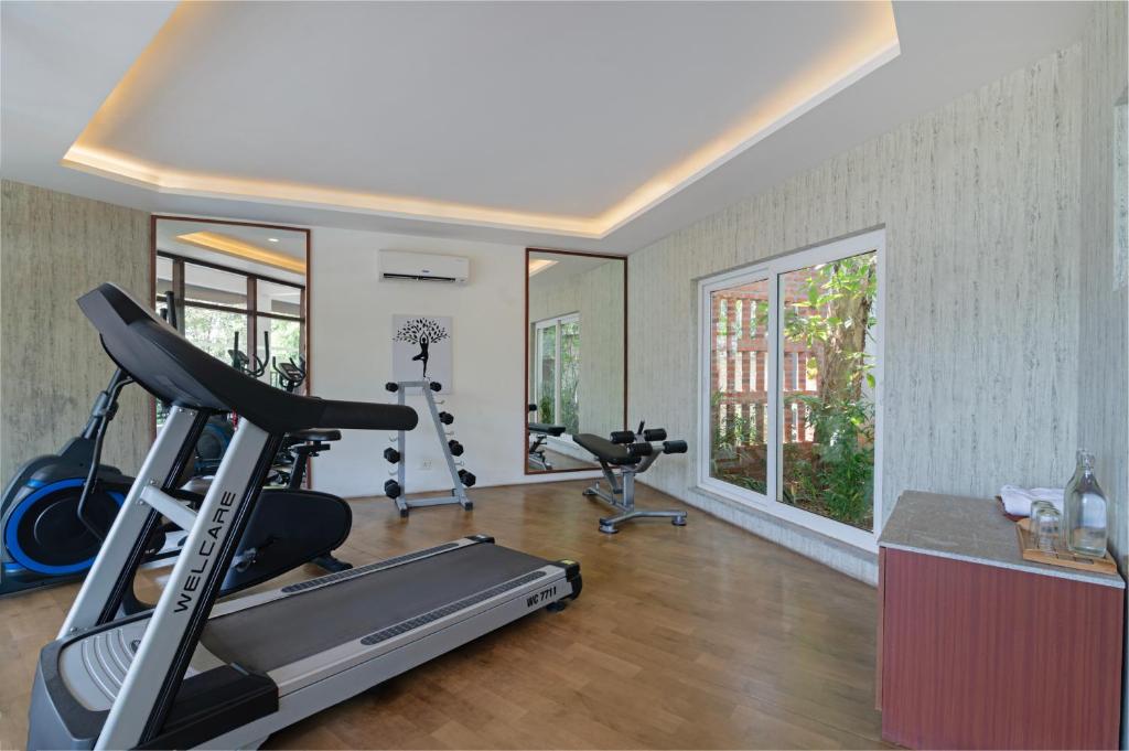 a gym with a treadmill and exercise bikes in a room at Sterling Wayanad in Sultan Bathery