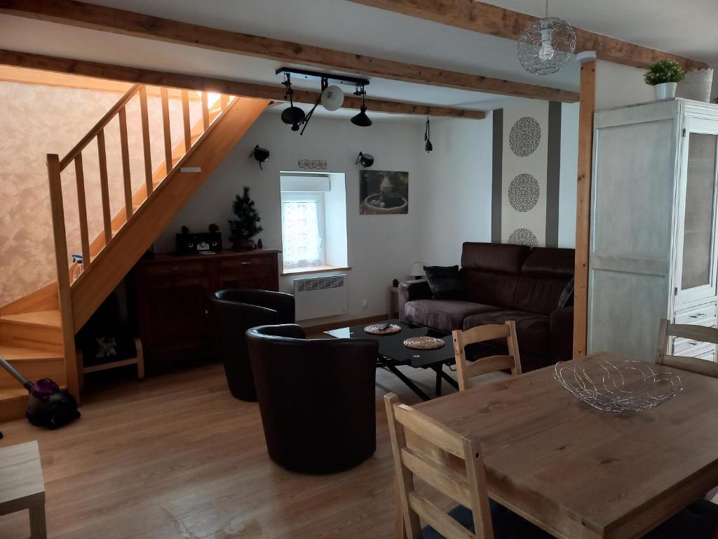 salon ze stołem i kanapą w obiekcie APPARTEMENT EN DUPLEX " LA DORDOGNE" dans maison individuelle w mieście Mont-Dore