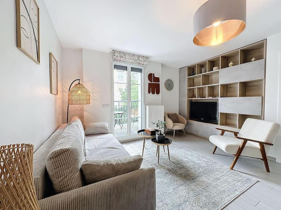 a living room with a couch and a table at Cozy apartment near Paris Disney - 6 min from train station in Villiers-sur-Marne