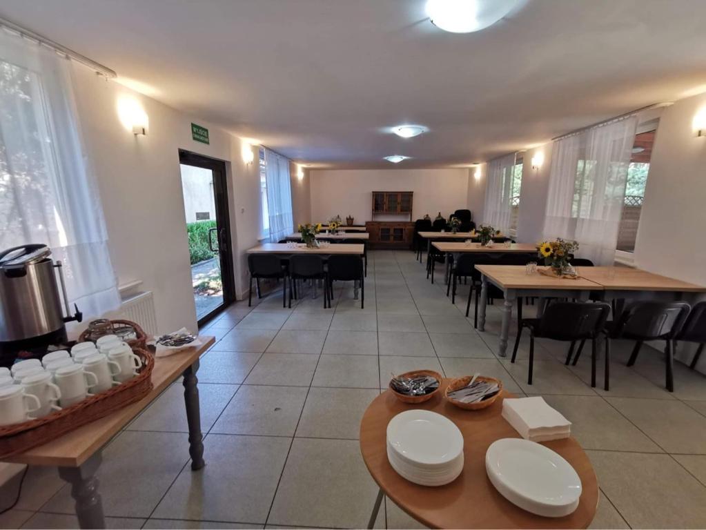 Spacious room with tables, chairs, and sunflowers; bright and welcoming atmosphere.