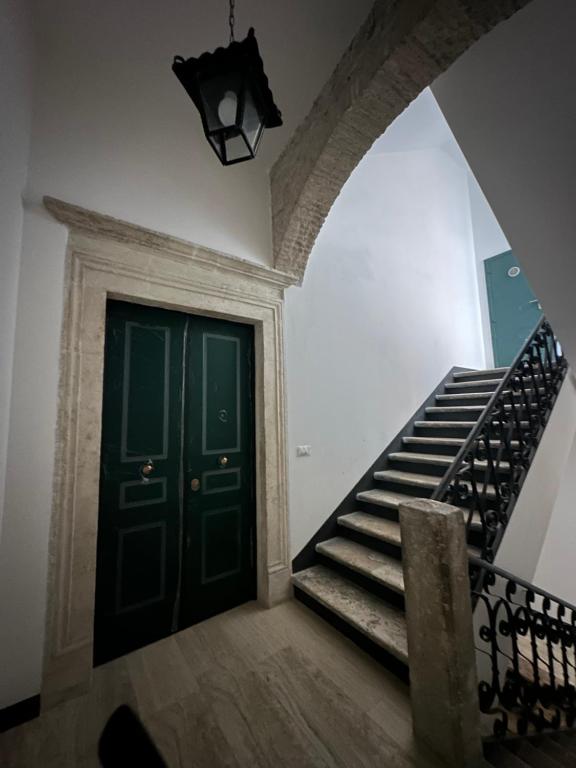 un corridoio con scala e porta verde di Case Pacifici in città ad Ascoli Piceno