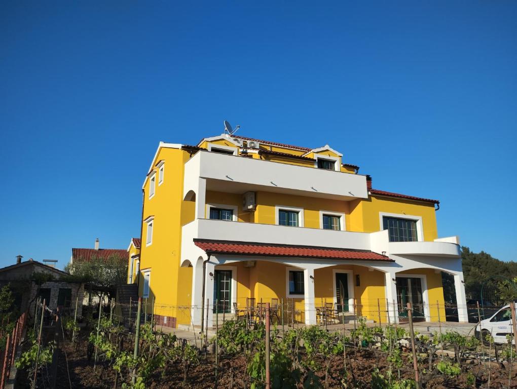 羅佐瓦克的住宿－科爾卡伊万旅館，山顶上一座黄色和白色的建筑