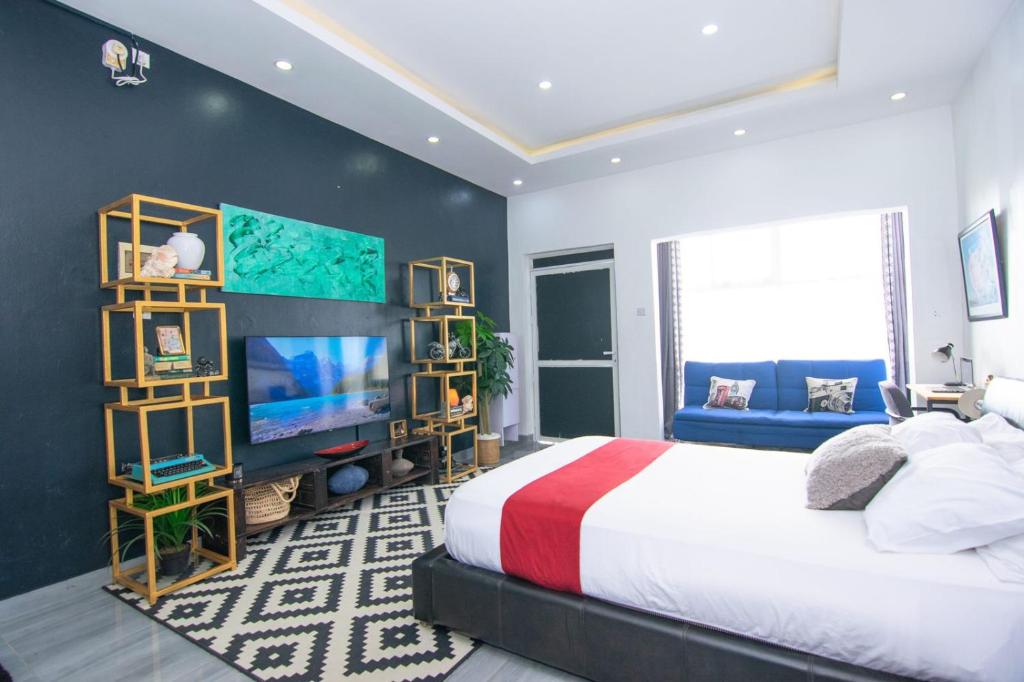 a bedroom with a large bed and a television at Beau Fahy Nyali studio apartment in Mombasa