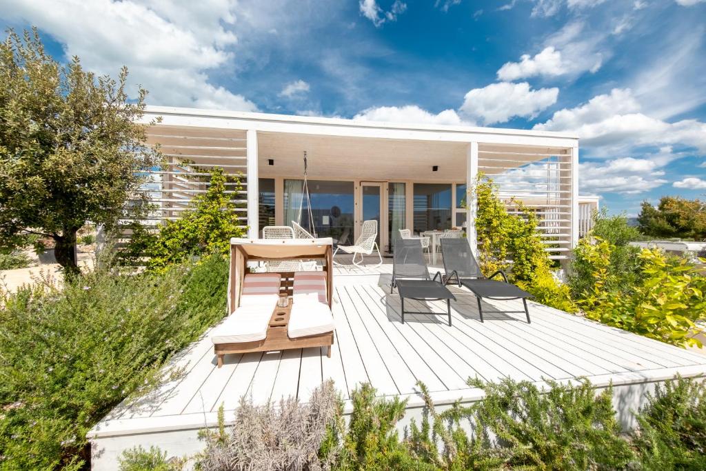 une terrasse avec des chaises et une table sur une maison dans l'établissement Buqez 58 - Drage villas, à Drage