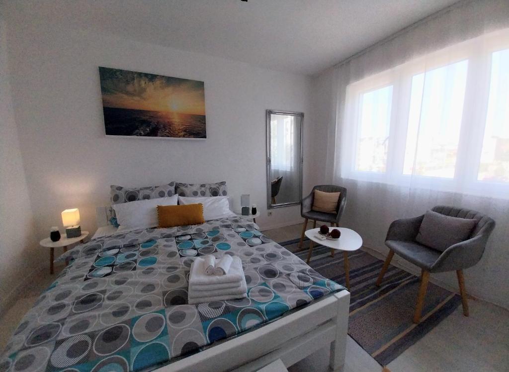 a bedroom with a large bed and two chairs at Studio M in Pula