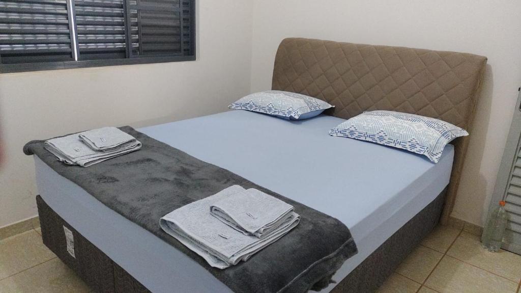 a bed with two pillows on it in a room at Casa Bela Vista da Serra da canastra in São Roque de Minas