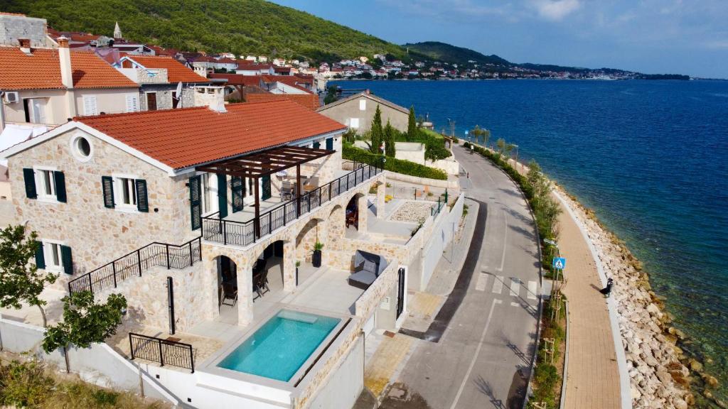 une maison avec une piscine à côté de l'océan dans l'établissement Villa Ocean View of Kali - Erste Meerreihe mit Pool, à Kali