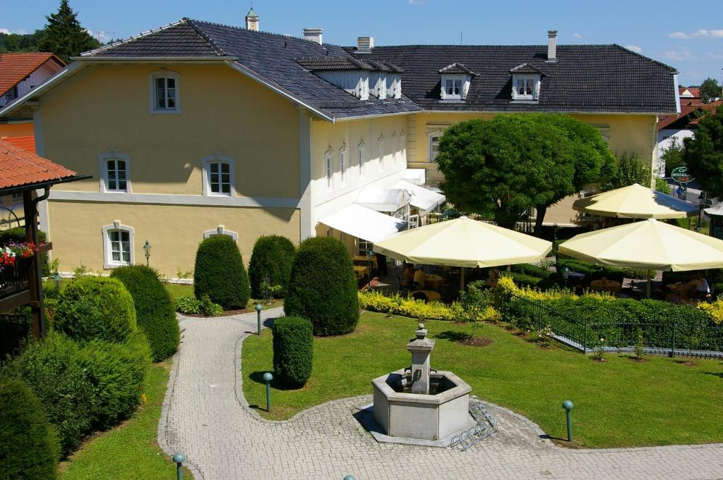 a building with a fountain in the middle of a garden at Sammareier Gutshof in Bad Birnbach