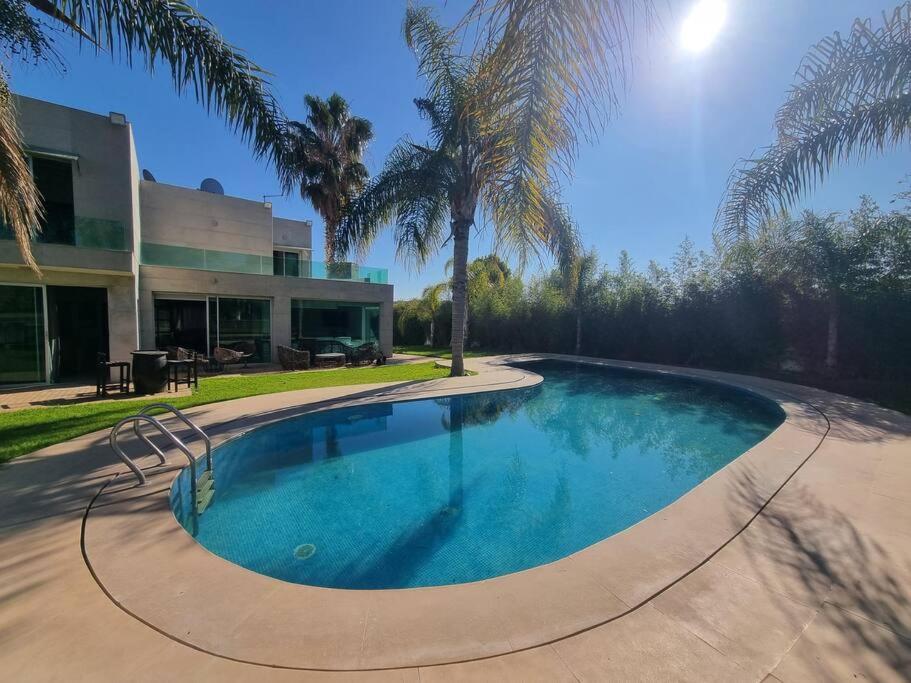una piscina frente a una casa con palmeras en Fes Villa with Pool - Serene Oasis Retreat - Fez en Aïn Smar