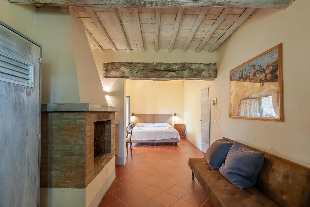 salon z łóżkiem i kominkiem w obiekcie Borgo Casa al Vento w mieście Gaiole in Chianti