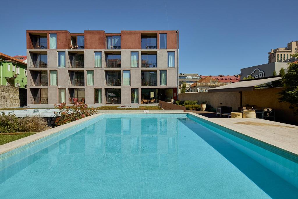 a large swimming pool in front of a building at Aparthotel Oporto Anselmo in Porto