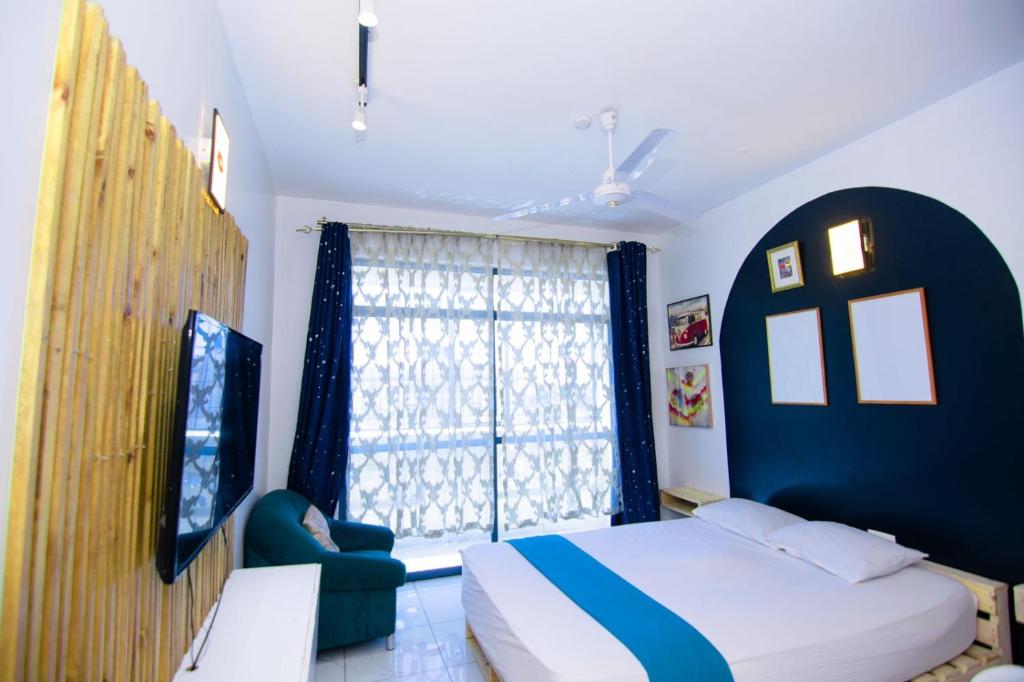 Mombasa bamburi staycation 2 في مومباسا: غرفة نوم بسرير ونافذة كبيرة